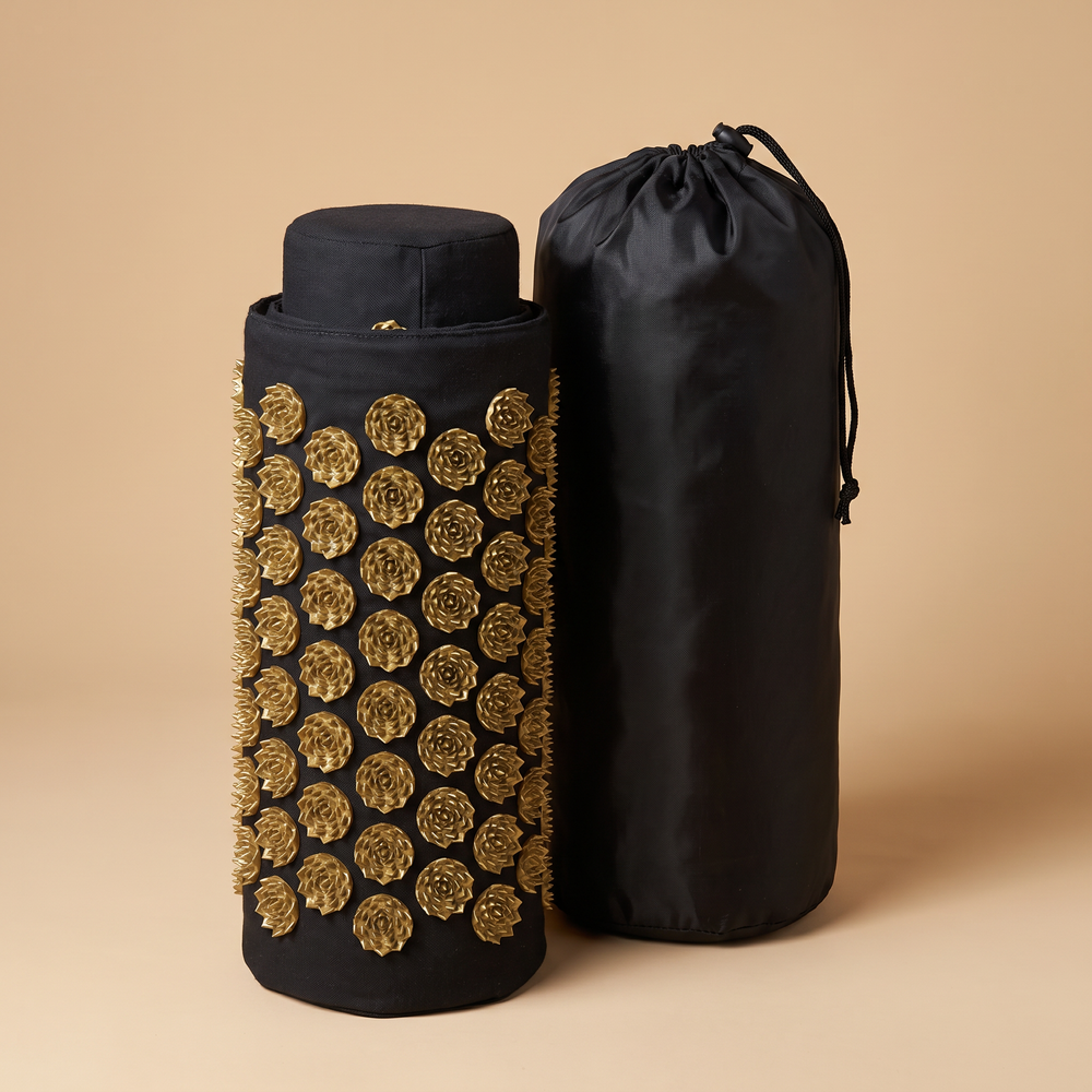 Rolled acupressure mat next to black drawstring storage bag